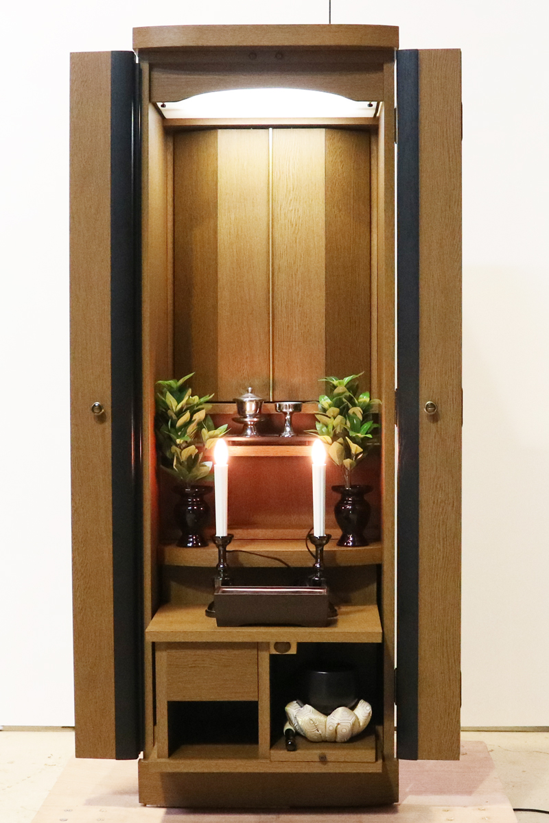 お求めやすいお値段となっております落ち着いた木目と色合いが人気です。ワンルームやマンションなどコンパクトな仏壇です。扉を閉めれば洋服ダンスのように見えます。リビング・ダイニング・洋室・和室・にぴったりの家具調仏壇となっております。補修箇所は掲載しております。 製品名 	創価学会家具調中古仏壇　K003　特装ご本尊様ご安置可能です。 設置 	和室・洋室・ワンルームにも最適です 種別 	家具調仏壇 サイズ 	  仏壇全体:高147cm x 幅49.5cm x 奥行き45cm  厨子内寸: 51cm x 39cm  外扉二つ折り幅:73cm  経机引き出した際の最大奥行:約57cm 	  材質 	MDF　 機能 	自動扉・照明灯・引き出し2箇所・特装ご本尊様ご安置可能です。