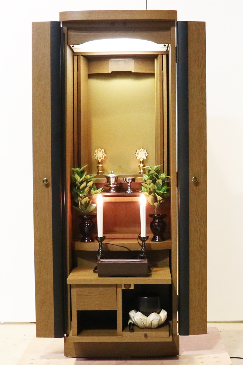 お求めやすいお値段となっております落ち着いた木目と色合いが人気です。ワンルームやマンションなどコンパクトな仏壇です。扉を閉めれば洋服ダンスのように見えます。リビング・ダイニング・洋室・和室・にぴったりの家具調仏壇となっております。補修箇所は掲載しております。 製品名 	創価学会家具調中古仏壇　K003　特装ご本尊様ご安置可能です。 設置 	和室・洋室・ワンルームにも最適です 種別 	家具調仏壇 サイズ 	  仏壇全体:高147cm x 幅49.5cm x 奥行き45cm  厨子内寸: 51cm x 39cm  外扉二つ折り幅:73cm  経机引き出した際の最大奥行:約57cm 	  材質 	MDF　 機能 	自動扉・照明灯・引き出し2箇所・特装ご本尊様ご安置可能です。