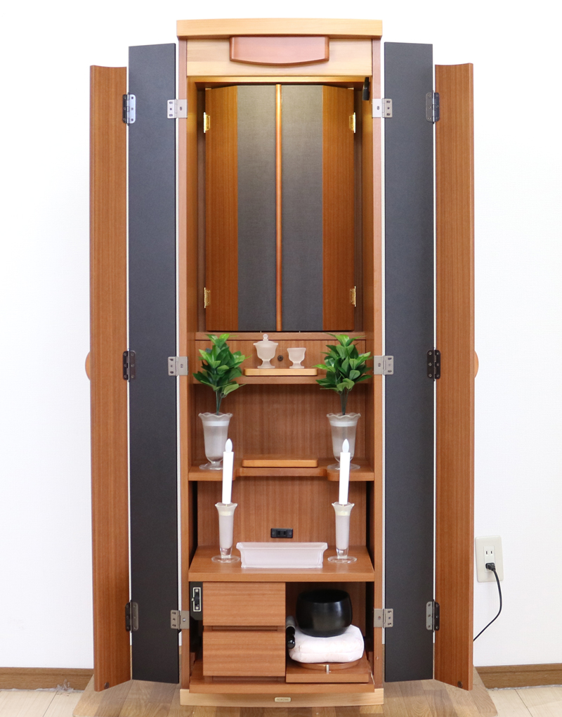 創価学会仏壇専門店桜梅桃李.comより発売いたします、創価学会家具調仏壇1472ライフウッド 今までのお仏壇のデザインではなかった、オシャレな雰囲気漂うデザイに仕上がっております。暖かみあふれる明るい印象をお部屋にプラスしてくれますダーク色と、明るいチーク色の木材、ライト色の木材のかわいらしい桜彫刻付き家具調仏壇です。  仏壇全体:高さ約147cm x 幅約44cm x 奥行き約43cm  扉最大幅約:86cm  二つ折り幅約:66.5cm  収納経机、最大奥行約:59cm  厨子内寸約: 56cm x 33cm  特装御本尊様がご安置できます彫刻:本黒檀無垢材インドネシア彫(チーク無垢材・クリキス無垢材・ジャンプ無垢材)女子部婦人部に大人気和室洋室にすっとなじみます