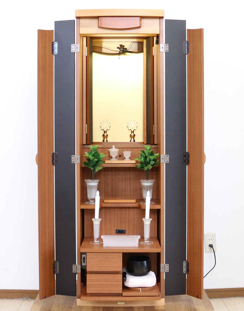 創価学会仏壇専門店桜梅桃李.comより発売いたします、創価学会家具調仏壇1472ライフウッド 今までのお仏壇のデザインではなかった、オシャレな雰囲気漂うデザイに仕上がっております。暖かみあふれる明るい印象をお部屋にプラスしてくれますダーク色と、明るいチーク色の木材、ライト色の木材のかわいらしい桜彫刻付き家具調仏壇です。  仏壇全体:高さ約147cm x 幅約44cm x 奥行き約43cm  扉最大幅約:86cm  二つ折り幅約:66.5cm  収納経机、最大奥行約:59cm  厨子内寸約: 56cm x 33cm  特装御本尊様がご安置できます彫刻:本黒檀無垢材インドネシア彫(チーク無垢材・クリキス無垢材・ジャンプ無垢材)女子部婦人部に大人気和室洋室にすっとなじみます