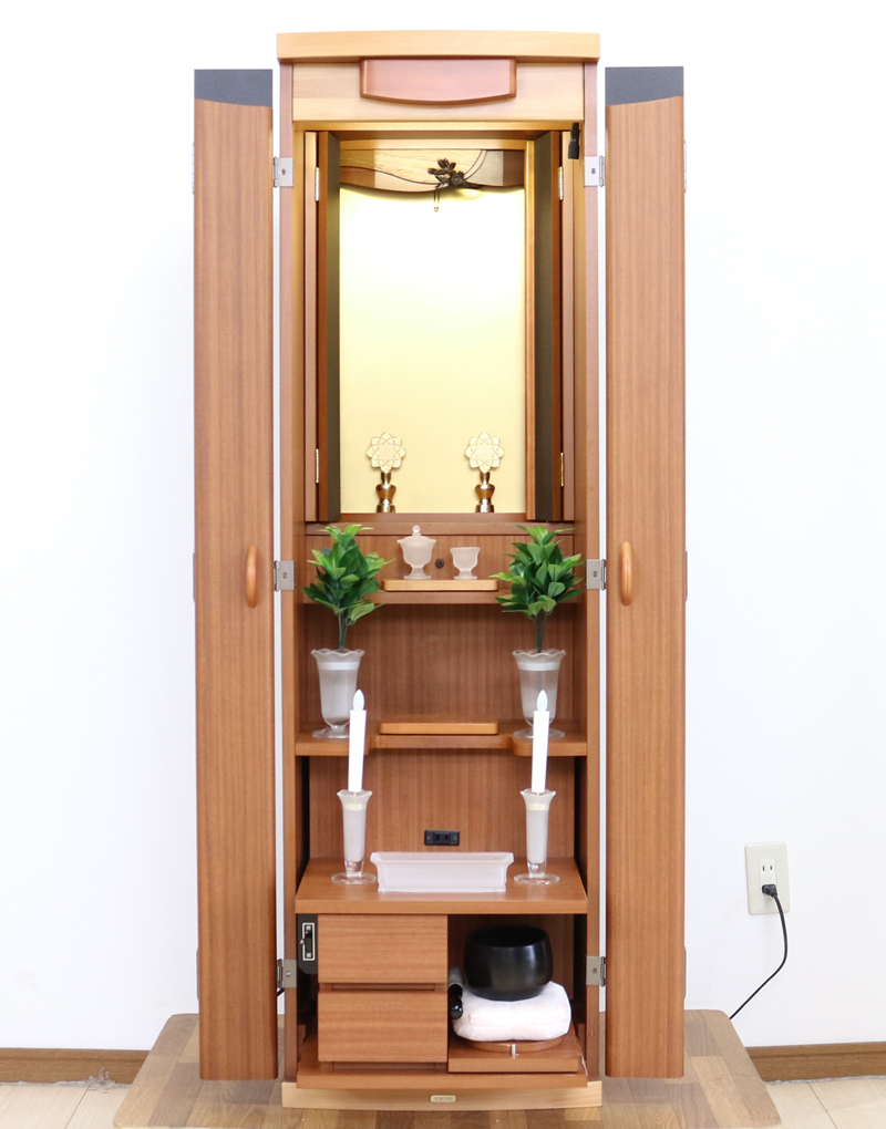 創価学会仏壇専門店桜梅桃李.comより発売いたします、創価学会家具調仏壇1472ライフウッド 今までのお仏壇のデザインではなかった、オシャレな雰囲気漂うデザイに仕上がっております。暖かみあふれる明るい印象をお部屋にプラスしてくれますダーク色と、明るいチーク色の木材、ライト色の木材のかわいらしい桜彫刻付き家具調仏壇です。  仏壇全体:高さ約147cm x 幅約44cm x 奥行き約43cm  扉最大幅約:86cm  二つ折り幅約:66.5cm  収納経机、最大奥行約:59cm  厨子内寸約: 56cm x 33cm  特装御本尊様がご安置できます彫刻:本黒檀無垢材インドネシア彫(チーク無垢材・クリキス無垢材・ジャンプ無垢材)女子部婦人部に大人気和室洋室にすっとなじみます