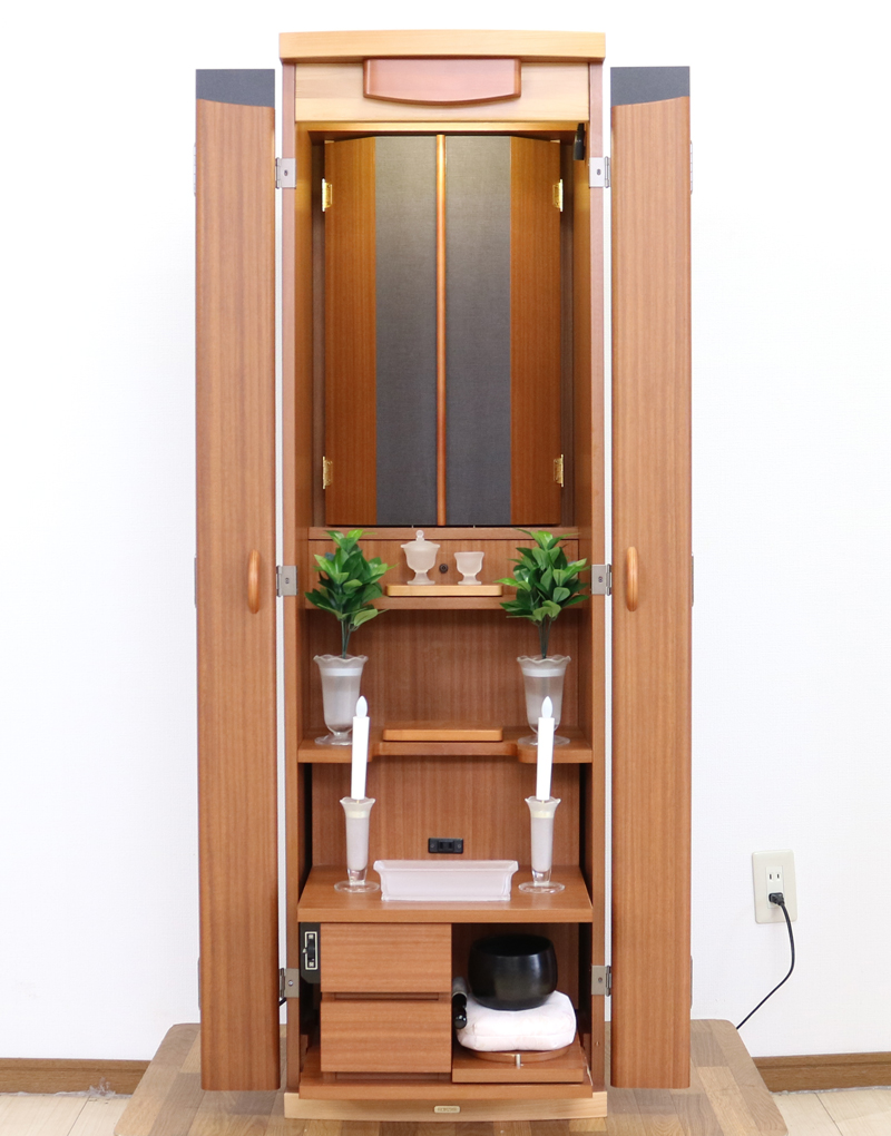 創価学会仏壇専門店桜梅桃李.comより発売いたします、創価学会家具調仏壇1472ライフウッド 今までのお仏壇のデザインではなかった、オシャレな雰囲気漂うデザイに仕上がっております。暖かみあふれる明るい印象をお部屋にプラスしてくれますダーク色と、明るいチーク色の木材、ライト色の木材のかわいらしい桜彫刻付き家具調仏壇です。  仏壇全体:高さ約147cm x 幅約44cm x 奥行き約43cm  扉最大幅約:86cm  二つ折り幅約:66.5cm  収納経机、最大奥行約:59cm  厨子内寸約: 56cm x 33cm  特装御本尊様がご安置できます彫刻:本黒檀無垢材インドネシア彫(チーク無垢材・クリキス無垢材・ジャンプ無垢材)女子部婦人部に大人気和室洋室にすっとなじみます