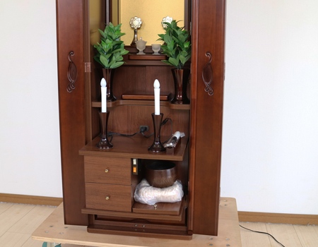 ダーク色とライト色のツートンのコンビネーション色です。今までのお仏壇のデザインではなかった、オシャレな雰囲気漂うデザインに仕上がっております。材質はデザインにあった、パイン材を使用しており、暖かみあふれる明るい印象をお部屋にプラスしてくれます。金剛堂アンサンブル現在でも販売されているお仏壇です。創価学会中古仏壇639和室・洋室・拠点・ワンルーム・一人暮らしにも最適です家具調仏壇仏壇全体:高さ145cm x 幅52.5cm x 奥行き49cm扉最大幅:79cm収納経机、最大奥行:56cm厨子内寸:53cm x 32.5cm　創価学会仏壇専門店桜梅桃李.comより発売いたします。創価学会中古家具調仏壇639のご案内でした。創価学会中古仏壇・創価学会新品仏壇・創価学会アウトレット仏壇を取り扱っております。ぜひご相談くださいませ。　仏具設置例