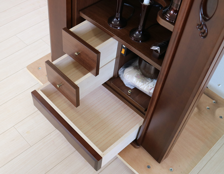 ダーク色とライト色のツートンのコンビネーション色です。今までのお仏壇のデザインではなかった、オシャレな雰囲気漂うデザインに仕上がっております。材質はデザインにあった、パイン材を使用しており、暖かみあふれる明るい印象をお部屋にプラスしてくれます。金剛堂アンサンブル現在でも販売されているお仏壇です。創価学会中古仏壇639和室・洋室・拠点・ワンルーム・一人暮らしにも最適です家具調仏壇仏壇全体:高さ145cm x 幅52.5cm x 奥行き49cm扉最大幅:79cm収納経机、最大奥行:56cm厨子内寸:53cm x 32.5cm　創価学会仏壇専門店桜梅桃李.comより発売いたします。創価学会中古家具調仏壇639のご案内でした。創価学会中古仏壇・創価学会新品仏壇・創価学会アウトレット仏壇を取り扱っております。ぜひご相談くださいませ。経机部分の収納は三か所ございます。