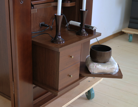 ダーク色とライト色のツートンのコンビネーション色です。今までのお仏壇のデザインではなかった、オシャレな雰囲気漂うデザインに仕上がっております。材質はデザインにあった、パイン材を使用しており、暖かみあふれる明るい印象をお部屋にプラスしてくれます。金剛堂アンサンブル現在でも販売されているお仏壇です。創価学会中古仏壇639和室・洋室・拠点・ワンルーム・一人暮らしにも最適です家具調仏壇仏壇全体:高さ145cm x 幅52.5cm x 奥行き49cm扉最大幅:79cm収納経机、最大奥行:56cm厨子内寸:53cm x 32.5cm　創価学会仏壇専門店桜梅桃李.comより発売いたします。創価学会中古家具調仏壇639のご案内でした。創価学会中古仏壇・創価学会新品仏壇・創価学会アウトレット仏壇を取り扱っております。ぜひご相談くださいませ。収納経机&スライド式リン台付属