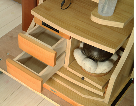  ダーク色とライト色のツートンのコンビネーション色です。今までのお仏壇のデザインではなかった、オシャレな雰囲気漂うデザインに仕上がっております。  材質はデザインにあった、パイン材を使用しており、暖かみあふれる明るい印象をお部屋にプラスしてくれます。  金剛堂アンサンブル現在でも販売されているお仏壇です。    製品名 	創価学会中古仏壇639 設置 	和室・洋室・拠点・ワンルーム・一人暮らしにも最適です 種別 	家具調仏壇 サイズ 	  仏壇全体:高さ145cm x 幅54cm x 奥行き49cm  扉二つ折り最大幅:79cm  厨子内寸: 52cm x 32cm 	  材質 	芯材:MDF、扉:パイン材、 機能 	  自動扉・引き出し3箇所(厨子下一個、下部引き出し二個)、収納経机