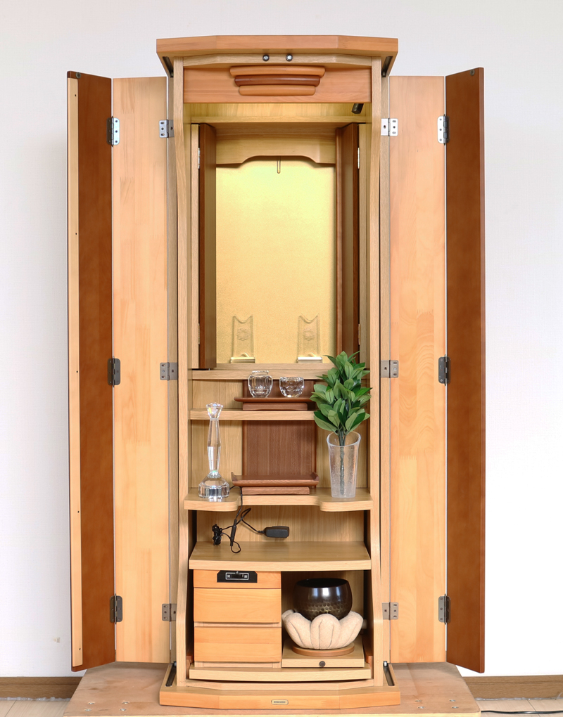 ダーク色とライト色のツートンのコンビネーション色です。今までのお仏壇のデザインではなかった、オシャレな雰囲気漂うデザインに仕上がっております。  材質はデザインにあった、パイン材を使用しており、暖かみあふれる明るい印象をお部屋にプラスしてくれます。  金剛堂アンサンブル現在でも販売されているお仏壇です。    製品名 	創価学会中古仏壇639 設置 	和室・洋室・拠点・ワンルーム・一人暮らしにも最適です 種別 	家具調仏壇 サイズ 	  仏壇全体:高さ145cm x 幅54cm x 奥行き49cm  扉二つ折り最大幅:79cm  厨子内寸: 52cm x 32cm 	  材質 	芯材:MDF、扉:パイン材、 機能 	  自動扉・引き出し3箇所(厨子下一個、下部引き出し二個)、収納経机