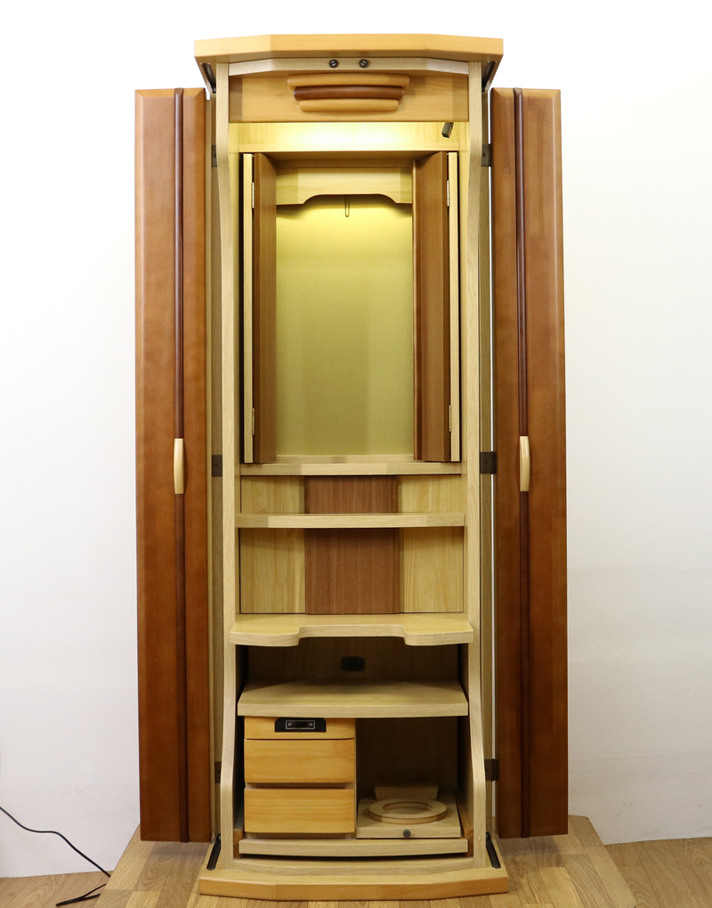 ダーク色とライト色のツートンのコンビネーション色です。今までのお仏壇のデザインではなかった、オシャレな雰囲気漂うデザインに仕上がっております。材質はデザインにあった、パイン材を使用しており、暖かみあふれる明るい印象をお部屋にプラスしてくれます。金剛堂アンサンブル現在でも販売されているお仏壇です。soukagakkai創価学会仏壇専門店桜梅桃李.comより発売いたします。中古仏壇アンサンブル　美品・格安創価学会仏壇・家具調仏壇・