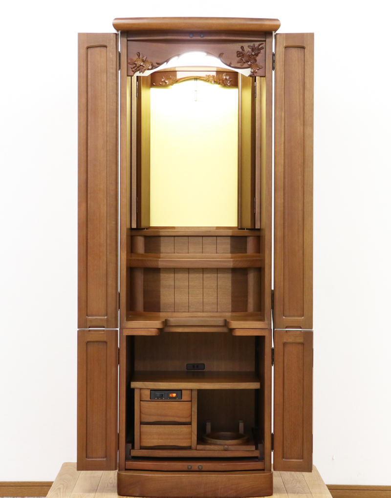 金剛堂製の二段重ねの家具調電動仏壇です。厨子上部に二重の桜の彫刻はオシャレな雰囲気漂うデザインに仕上がっております。  材質はデザインにあった、マホガニー材を使用しており、暖かみあふれる明るい印象をお部屋にプラスしてくれます。  和室・洋室・リビングダイニングにも最適です。また厨子内は、金箔を使用しておりご本尊様を明るく荘厳いたします。 製品名 	創価学会　家具調電動中古仏壇717金剛堂製 設置 	和室・洋室・拠点にも最適です 種別 	中古家具調仏壇 サイズ 	  仏壇全体:高さ約150cm x 幅約53cm x 奥行き約49cm  厨子内寸:約51cm x 約35cm (特装ご本尊様可能) 	  材質 	マホガニー無垢、貼り、合成杢、MDF 機能 自動開閉厨子・蛍光照明・厨子内金箔