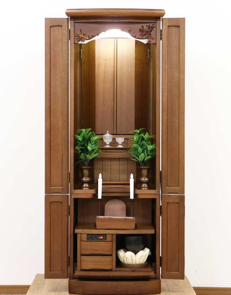 金剛堂製の二段重ねの家具調電動仏壇です。厨子上部に二重の桜の彫刻はオシャレな雰囲気漂うデザインに仕上がっております。  材質はデザインにあった、マホガニー材を使用しており、暖かみあふれる明るい印象をお部屋にプラスしてくれます。  和室・洋室・リビングダイニングにも最適です。また厨子内は、金箔を使用しておりご本尊様を明るく荘厳いたします。 製品名 	創価学会　家具調電動中古仏壇717金剛堂製 設置 	和室・洋室・拠点にも最適です 種別 	中古家具調仏壇 サイズ 	  仏壇全体:高さ約150cm x 幅約53cm x 奥行き約49cm  厨子内寸:約51cm x 約35cm (特装ご本尊様可能) 	  材質 	マホガニー無垢、貼り、合成杢、MDF 機能 自動開閉厨子・蛍光照明・厨子内金箔