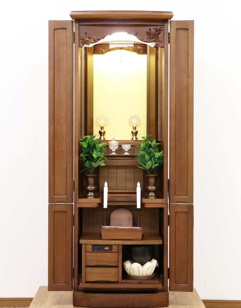 金剛堂製の二段重ねの家具調電動仏壇です。厨子上部に二重の桜の彫刻はオシャレな雰囲気漂うデザインに仕上がっております。  材質はデザインにあった、マホガニー材を使用しており、暖かみあふれる明るい印象をお部屋にプラスしてくれます。  和室・洋室・リビングダイニングにも最適です。また厨子内は、金箔を使用しておりご本尊様を明るく荘厳いたします。 製品名 	創価学会　家具調電動中古仏壇717金剛堂製 設置 	和室・洋室・拠点にも最適です 種別 	中古家具調仏壇 サイズ 	  仏壇全体:高さ約150cm x 幅約53cm x 奥行き約49cm  厨子内寸:約51cm x 約35cm (特装ご本尊様可能) 	  材質 	マホガニー無垢、貼り、合成杢、MDF 機能 自動開閉厨子・蛍光照明・厨子内金箔