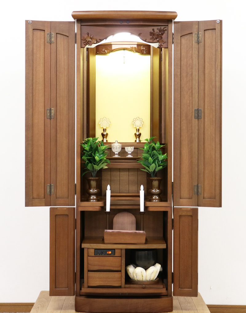 金剛堂製の二段重ねの家具調電動仏壇です。厨子上部に二重の桜の彫刻はオシャレな雰囲気漂うデザインに仕上がっております。  材質はデザインにあった、マホガニー材を使用しており、暖かみあふれる明るい印象をお部屋にプラスしてくれます。  和室・洋室・リビングダイニングにも最適です。また厨子内は、金箔を使用しておりご本尊様を明るく荘厳いたします。 製品名 	創価学会　家具調電動中古仏壇717金剛堂製 設置 	和室・洋室・拠点にも最適です 種別 	中古家具調仏壇 サイズ 	  仏壇全体:高さ約150cm x 幅約53cm x 奥行き約49cm  厨子内寸:約51cm x 約35cm (特装ご本尊様可能) 	  材質 	マホガニー無垢、貼り、合成杢、MDF 機能 自動開閉厨子・蛍光照明・厨子内金箔