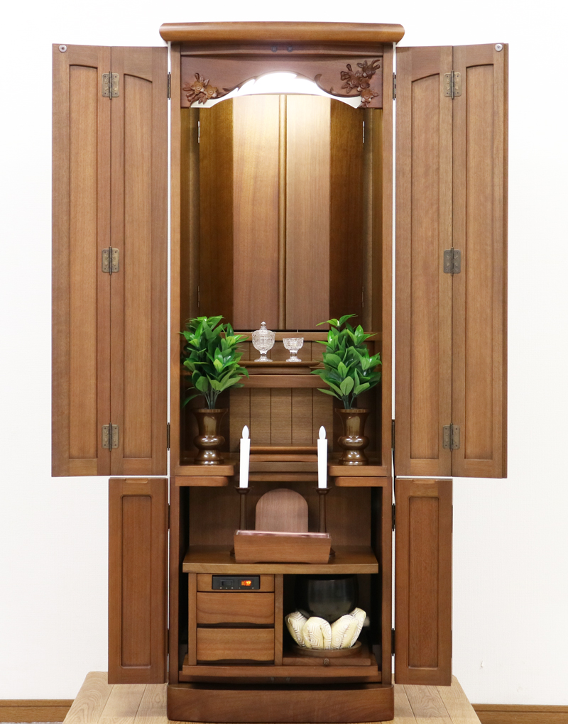 金剛堂製の二段重ねの家具調電動仏壇です。厨子上部に二重の桜の彫刻はオシャレな雰囲気漂うデザインに仕上がっております。  材質はデザインにあった、マホガニー材を使用しており、暖かみあふれる明るい印象をお部屋にプラスしてくれます。  和室・洋室・リビングダイニングにも最適です。また厨子内は、金箔を使用しておりご本尊様を明るく荘厳いたします。 製品名 	創価学会　家具調電動中古仏壇717金剛堂製 設置 	和室・洋室・拠点にも最適です 種別 	中古家具調仏壇 サイズ 	  仏壇全体:高さ約150cm x 幅約53cm x 奥行き約49cm  厨子内寸:約51cm x 約35cm (特装ご本尊様可能) 	  材質 	マホガニー無垢、貼り、合成杢、MDF 機能 自動開閉厨子・蛍光照明・厨子内金箔