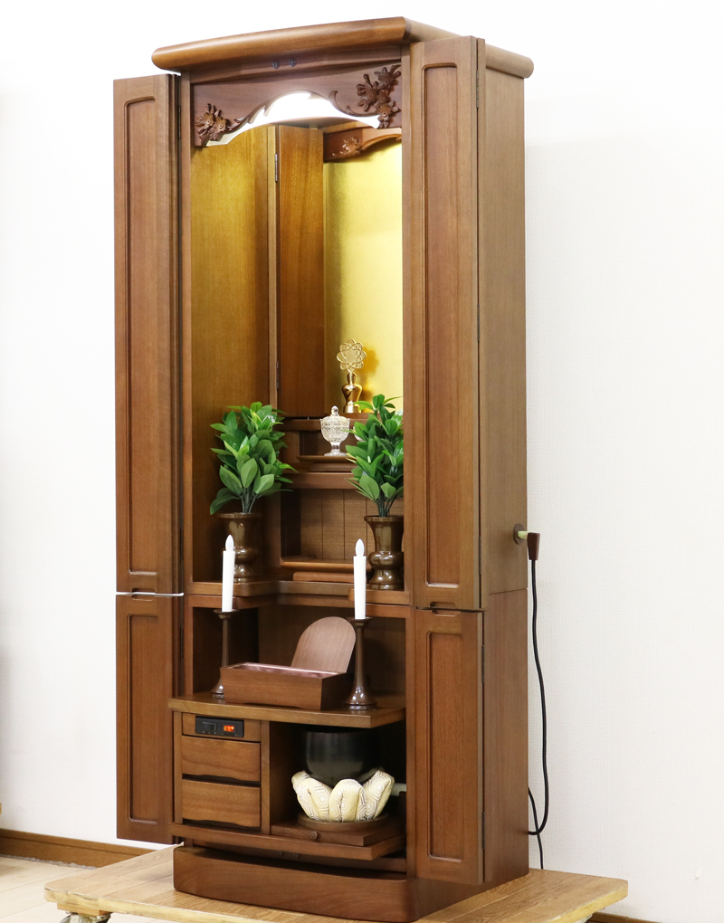 金剛堂製の二段重ねの家具調電動仏壇です。厨子上部に二重の桜の彫刻はオシャレな雰囲気漂うデザインに仕上がっております。  材質はデザインにあった、マホガニー材を使用しており、暖かみあふれる明るい印象をお部屋にプラスしてくれます。  和室・洋室・リビングダイニングにも最適です。また厨子内は、金箔を使用しておりご本尊様を明るく荘厳いたします。 製品名 	創価学会　家具調電動中古仏壇717金剛堂製 設置 	和室・洋室・拠点にも最適です 種別 	中古家具調仏壇 サイズ 	  仏壇全体:高さ約150cm x 幅約53cm x 奥行き約49cm  厨子内寸:約51cm x 約35cm (特装ご本尊様可能) 	  材質 	マホガニー無垢、貼り、合成杢、MDF 機能 自動開閉厨子・蛍光照明・厨子内金箔