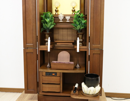 金剛堂製の二段重ねの家具調電動仏壇です。厨子上部に二重の桜の彫刻はオシャレな雰囲気漂うデザインに仕上がっております。  材質はデザインにあった、マホガニー材を使用しており、暖かみあふれる明るい印象をお部屋にプラスしてくれます。  和室・洋室・リビングダイニングにも最適です。また厨子内は、金箔を使用しておりご本尊様を明るく荘厳いたします。 製品名 	創価学会　家具調電動中古仏壇717金剛堂製 設置 	和室・洋室・拠点にも最適です 種別 	中古家具調仏壇 サイズ 	  仏壇全体:高さ約150cm x 幅約53cm x 奥行き約49cm  厨子内寸:約51cm x 約35cm (特装ご本尊様可能) 	  材質 	マホガニー無垢、貼り、合成杢、MDF 機能 自動開閉厨子・蛍光照明・厨子内金箔