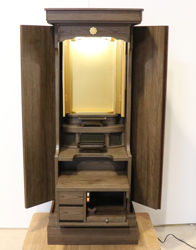 落ち着いたダーク色のお仏壇です。扉を閉めれば洋服ダンスのように見えます。リビング・ダイニング・洋室・和室・にぴったりの家具調仏壇となっております。補修箇所は掲載しております。B級仏壇の為よくご確認の上ご購入ください。製品名 創価学会家具調中古仏壇　BK002設置 和室・洋室・ワンルームにも最適です種別 家具調仏壇サイズ仏壇全体:高149.5cm x 幅59.5cm x 奥行き47.5cm厨子内寸:56cm x 30cm外扉の最大横幅:104.5cm経机引き出した際の最大奥行:約60cm材質 MDF　機能 自動扉・照明灯・引き出し2箇所・特装ご本尊様ご安置可能　格安激安最安値にて販売いたします