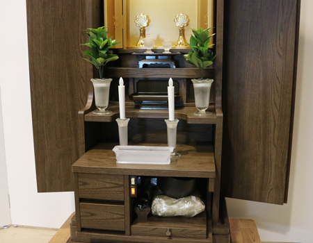 落ち着いたダーク色のお仏壇です。扉を閉めれば洋服ダンスのように見えます。リビング・ダイニング・洋室・和室・にぴったりの家具調仏壇となっております。補修箇所は掲載しております。B級仏壇の為よくご確認の上ご購入ください。製品名 創価学会家具調中古仏壇　BK002設置 和室・洋室・ワンルームにも最適です種別 家具調仏壇サイズ仏壇全体:高149.5cm x 幅59.5cm x 奥行き47.5cm厨子内寸:56cm x 30cm外扉の最大横幅:104.5cm経机引き出した際の最大奥行:約60cm材質 MDF　機能 自動扉・照明灯・引き出し2箇所・特装ご本尊様ご安置可能　格安激安最安値にて販売いたします