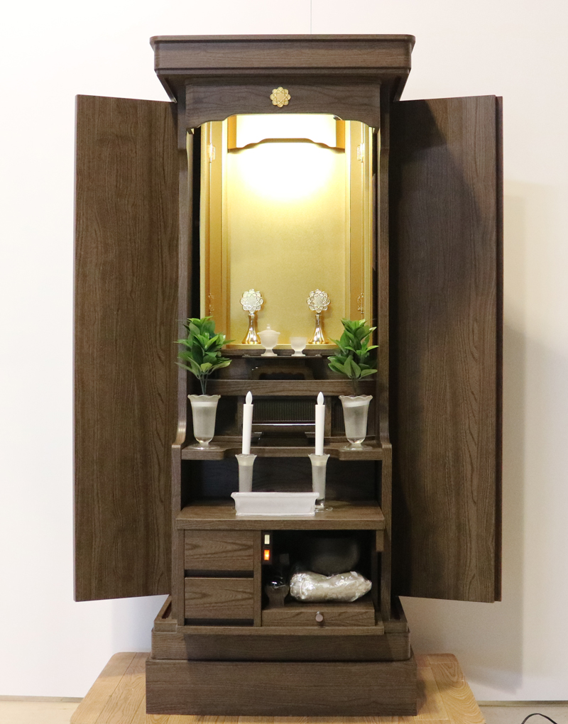 落ち着いたダーク色のお仏壇です。扉を閉めれば洋服ダンスのように見えます。リビング・ダイニング・洋室・和室・にぴったりの家具調仏壇となっております。補修箇所は掲載しております。B級仏壇の為よくご確認の上ご購入ください。製品名 創価学会家具調中古仏壇　BK002設置 和室・洋室・ワンルームにも最適です種別 家具調仏壇サイズ仏壇全体:高149.5cm x 幅59.5cm x 奥行き47.5cm厨子内寸:56cm x 30cm外扉の最大横幅:104.5cm経机引き出した際の最大奥行:約60cm材質 MDF　機能 自動扉・照明灯・引き出し2箇所・特装ご本尊様ご安置可能　格安激安最安値にて販売いたします