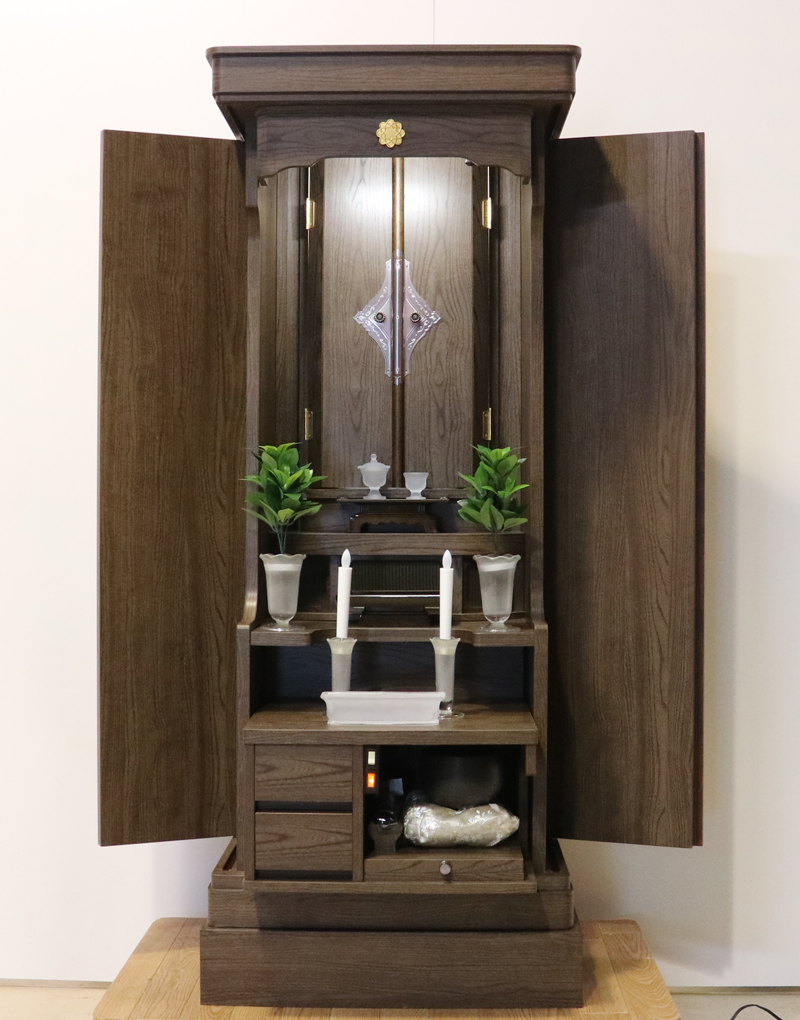 落ち着いたダーク色のお仏壇です。扉を閉めれば洋服ダンスのように見えます。リビング・ダイニング・洋室・和室・にぴったりの家具調仏壇となっております。補修箇所は掲載しております。B級仏壇の為よくご確認の上ご購入ください。製品名 創価学会家具調中古仏壇　BK002設置 和室・洋室・ワンルームにも最適です種別 家具調仏壇サイズ仏壇全体:高149.5cm x 幅59.5cm x 奥行き47.5cm厨子内寸:56cm x 30cm外扉の最大横幅:104.5cm経机引き出した際の最大奥行:約60cm材質 MDF　機能 自動扉・照明灯・引き出し2箇所・特装ご本尊様ご安置可能　格安激安最安値にて販売いたします