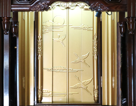 創価学会仏壇専門店桜梅桃李.comより発売いたします、会場拠点用鉄刀木　伝統型押込み扉仏壇KB004です。  経机・花台・リン台付きで、本格的なお仏壇となります。 製品名 	  創価学会中古仏壇　KB004 設置 	和室・洋室・拠点・男子部拠点にも最適です 種別 	厨子型電動仏壇 サイズ 	   仏壇本体　高さ:約173cm ×幅:約91cm×奥行:約74cm  扉最大の幅:約48cm  厨子内　高さ:約60cm×幅:約37cm  経机　高さ:約41cm×幅:約78cm×奥行:約41cm 	  材質 	鉄刀木・貼り・無垢・MDF 機能 	  スイッチ式電動扉  経机引き出し2箇所・仏壇本体引き出し4か所　計6箇所  掲載仏具一式付き(造花しきみ二本・仏器茶器のみ新品)  厨子背板を、新品の金吹きの塗装板に替えました。