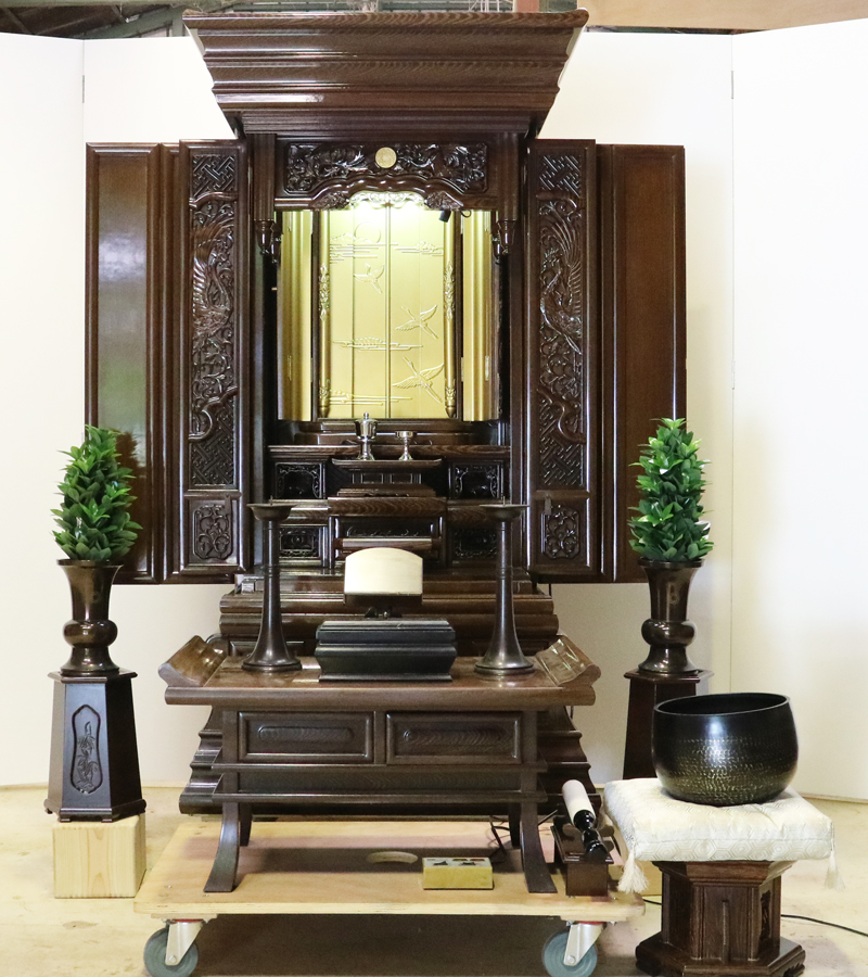 創価学会仏壇専門店桜梅桃李.comより発売いたします、会場拠点用鉄刀木　伝統型押込み扉仏壇KB004です。  経机・花台・リン台付きで、本格的なお仏壇となります。 製品名 	  創価学会中古仏壇　KB004 設置 	和室・洋室・拠点・男子部拠点にも最適です 種別 	厨子型電動仏壇 サイズ 	   仏壇本体　高さ:約173cm ×幅:約91cm×奥行:約74cm  扉最大の幅:約48cm  厨子内　高さ:約60cm×幅:約37cm  経机　高さ:約41cm×幅:約78cm×奥行:約41cm 	  材質 	鉄刀木・貼り・無垢・MDF 機能 	  スイッチ式電動扉  経机引き出し2箇所・仏壇本体引き出し4か所　計6箇所  掲載仏具一式付き(造花しきみ二本・仏器茶器のみ新品)  厨子背板を、新品の金吹きの塗装板に替えました。